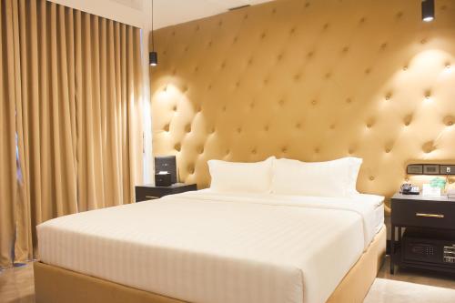a bedroom with a large bed with a large headboard at The Blu Hotel in Baranghauon