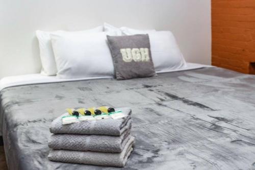 a bed with towels and pillows on top of it at Centric Modern Loft w/ King Beds in Rochester