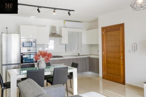 a kitchen and dining room with a table and chairs at Stunning 3BR w/Country View Apartment in M'Scalak by 360 Estates in Marsaskala