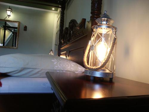 a lantern on a table next to a bed at Edinburgh in Mariánské Lázně