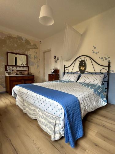 a bedroom with a large bed with a blue and white blanket at Angie&zii in Cormòns