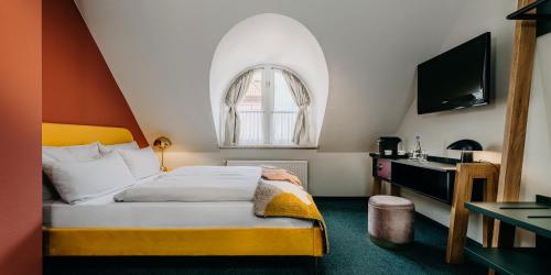Schlafzimmer mit einem Bett und einem Fenster in der Unterkunft Boutique-Hotel Zur alten Post - Stammhaus in Büsum