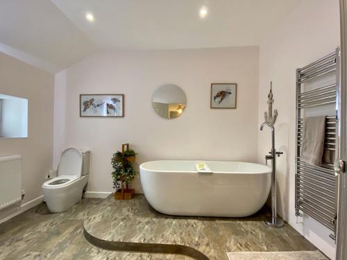 ein weißes Badezimmer mit Badewanne und Toilette in der Unterkunft Skipper’s Cottage - Perfect for Cardiff & Penarth in Cardiff