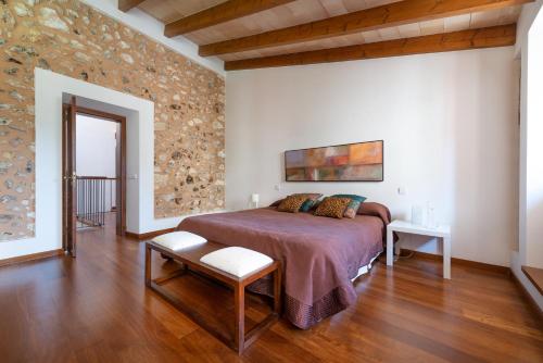 a bedroom with a bed and a stone wall at Can Puça -Sa Pobla- in Sa Pobla
