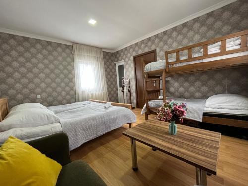 a bedroom with two bunk beds and a table at Hillside Guesthouse in Borjomi