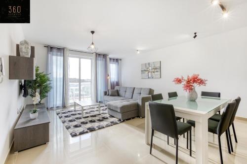 uma sala de estar com uma mesa e um sofá em Stunning 3BR w/Country View Apartment in M'Scalak by 360 Estates em Marsaskala