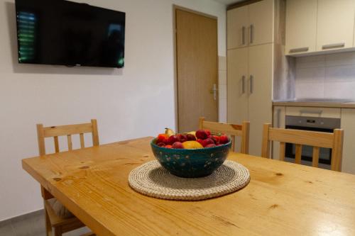 a bowl of fruit sitting on top of a wooden table at Andy's Holiday Home with HotTub & Sauna in Podbočje
