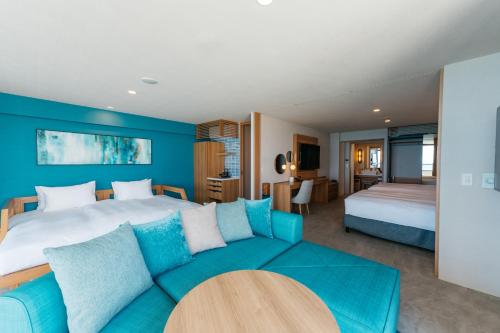 a bedroom with a large bed and a couch at AQUASENSE Hotel & Resort in Onna