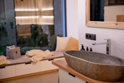 ein Badezimmer mit einem Steinwaschbecken auf der Theke in der Unterkunft Heselehof Waldchalets in Langenwang