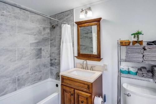 a bathroom with a sink and a tub and a shower at Fabulous House near Airpt/DwTN/UofR in Rochester