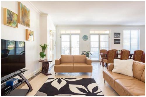 ein Wohnzimmer mit einem Sofa und einem Tisch in der Unterkunft Charming, Cosy, Classic Executive 1 Bedroom Apartment in Perth