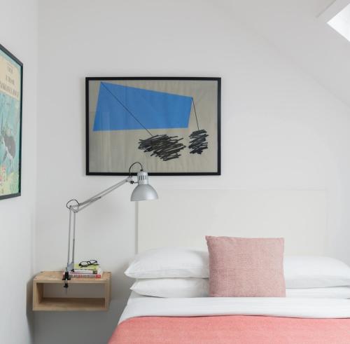 - une chambre avec un lit doté d'une couverture rose et d'une lampe dans l'établissement The Stop, à Galway