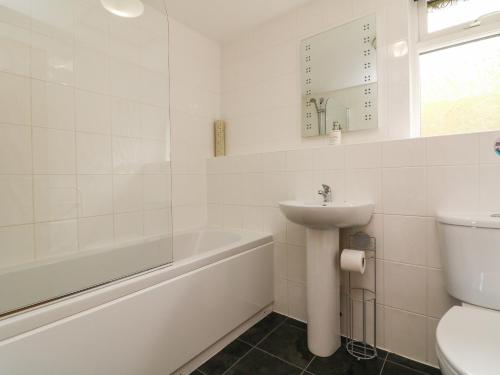 a bathroom with a sink and a tub and a toilet at Chalet Log Cabin L15 in Ilfracombe