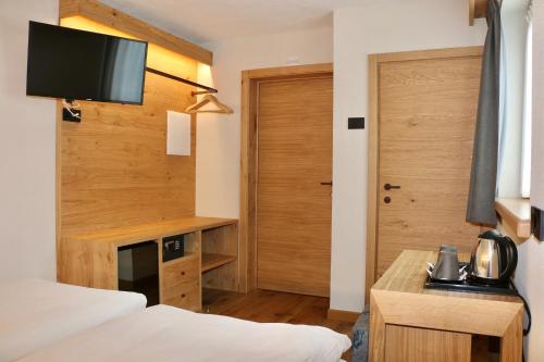 a room with two beds and a desk and a door at Hotel Galli's - Centro in Livigno