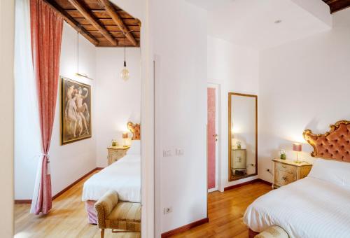 a bedroom with two beds and a mirror at Pantheon Caravaggio's House in Rome