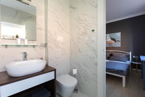 łazienka z białą umywalką i toaletą w obiekcie Apartment Libelle 5 star apartment in Krk! w Krku