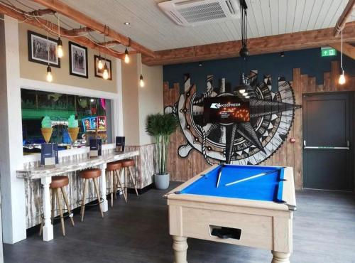 a bar with a pool table in a restaurant at Susie's Beautiful Caravan near the sea in Pwllheli