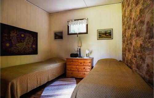 a bedroom with two beds and a dresser and a window at 2 Bedroom Lovely Home In Slite in Slite