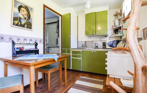 a kitchen with green cabinets and a wooden table at 2 Bedroom Lovely Home In Slite in Slite