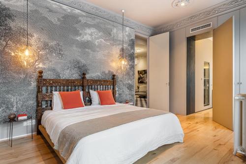 um quarto com uma cama grande e almofadas laranja em BNBHolder Luxe GRAN VIA em Madri