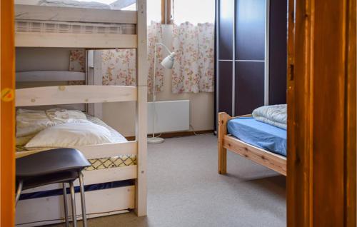a bunk bed room with two bunk beds and a chair at Hovden Alpin Apartments in Hovden