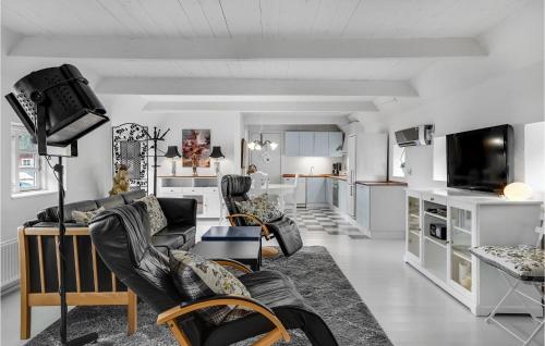 a living room with black leather chairs and a tv at One-Bedroom Apartment In Storvorde in Storvorde