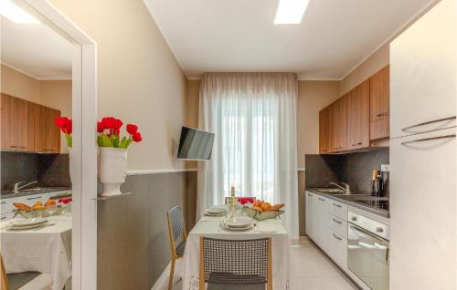 a kitchen with a table with red flowers on it at Trilo Sup in Alba Adriatica