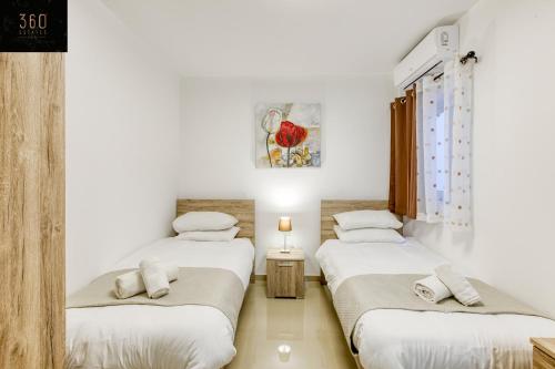 três camas num quarto com paredes brancas em Stunning 3BR w/Country View Apartment in M'Scalak by 360 Estates em Marsaskala