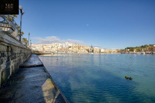 a large body of water with buildings in the background at Stunning 3BR w/Country View Apartment in M'Scalak by 360 Estates in Marsaskala