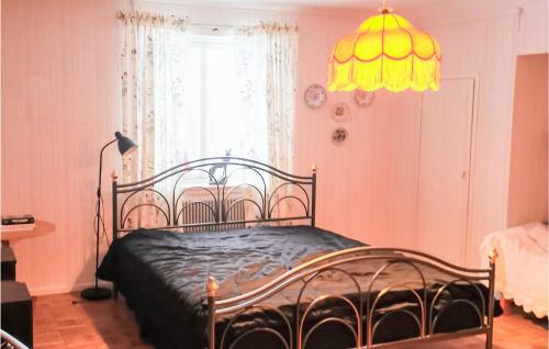 a bedroom with a bed and a chandelier at Amazing Home In Karlsviken With Wifi And 4 Bedrooms 