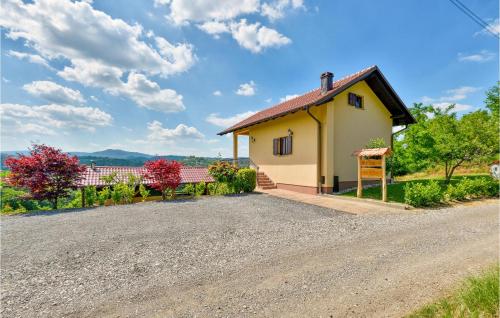 a small yellow house with a gravel driveway at Amazing Home In Adamovec With Sauna in Adamovec