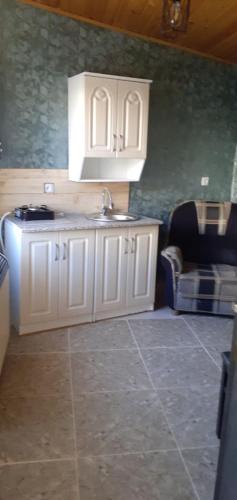a kitchen with white cabinets and a sink at Kaxa Shorena Guest-House in Stepantsminda