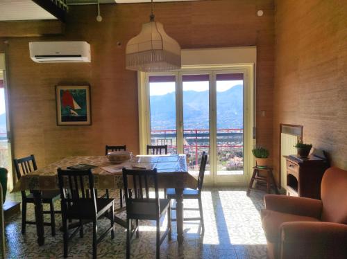 comedor con mesa y sillas y ventana grande en La Casa Del Nonno, en Monreale