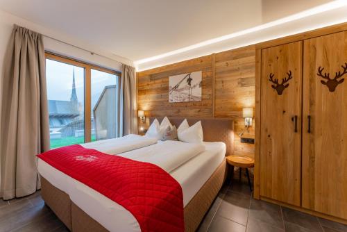 een slaapkamer met een groot bed en een rode deken bij AlpenParks Appartements Maria Alm in Maria Alm am Steinernen Meer