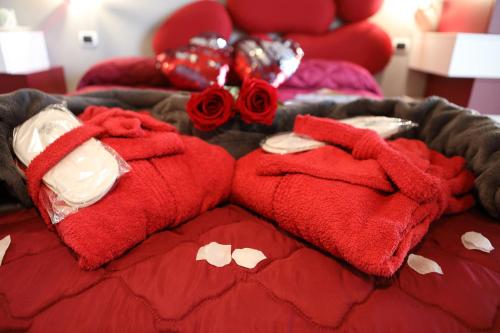 a bed with red towels and roses on it at B&B Bellavista Exclusive in zona centrale con piscina riscaldata e Jacuzzi vista lago LA COLAZIONE viene servita in una pasticceria rinomata ed esclusiva esterna alla struttura in Desenzano del Garda