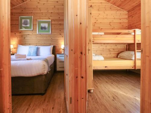a bedroom with two bunk beds in a log cabin at Chalet Lodge Bunks L1 in Ilfracombe