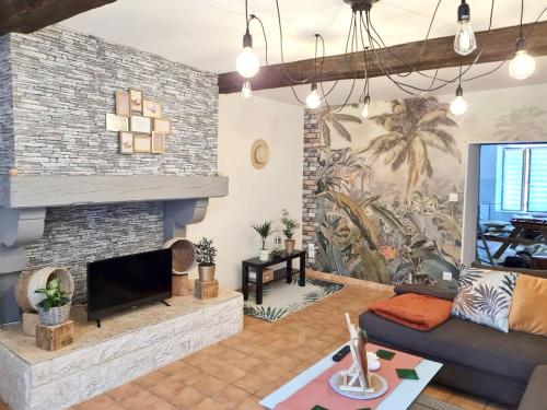 ein Wohnzimmer mit einem Sofa und einem Kamin in der Unterkunft Maison de 2 chambres avec terrasse a Deville in Deville