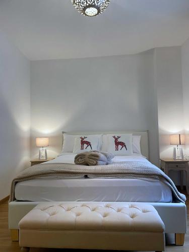 a bedroom with a large white bed with two lamps at Ai Tre Garofani B&B in Trento