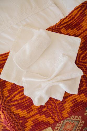 a piece of white cloth laying on a bed at Mai Danube in Eşelniţa