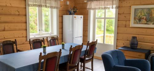 a dining room with a table and a refrigerator at Kabelvåg Feriehus & Camping in Kabelvåg