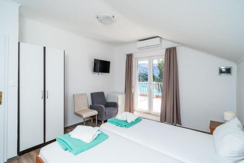 a hotel room with two beds and a window at Guest House Daniela in Mlini