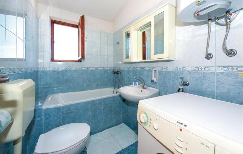 a blue and white bathroom with a toilet and a sink at Cozy Apartment In Kanica With Wifi in Zaglavice