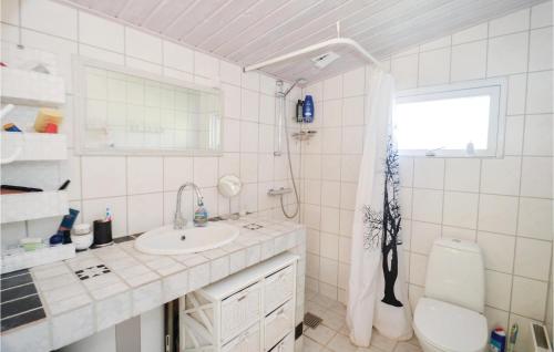 a bathroom with a sink and a toilet and a window at Cozy Home In Vggerlse With Kitchen in Bøtø By