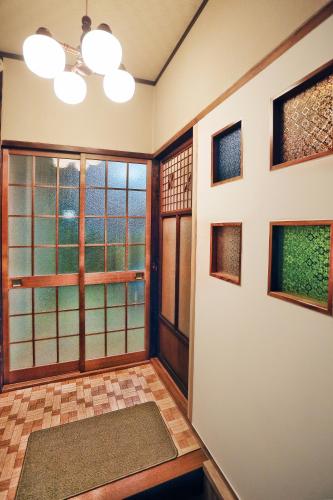 a room with doors and windows with a view at Bighem Maison 2 in Izumi-Sano