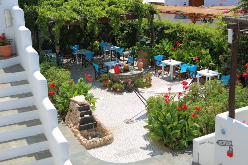 an outdoor patio with tables and chairs and flowers at Eleni Dream Village in Parikia