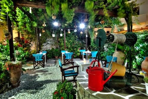 a patio with tables and chairs and a water fountain at Eleni Dream Village in Parikia