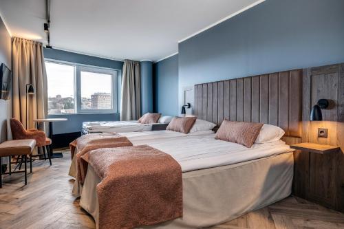 En eller flere senge i et værelse på Anker Hotel
