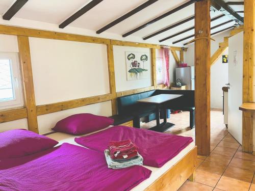 a room with a bed with purple sheets and a desk at Ferienhaus-Elisabeth Bungalow-Tom Bungalow-Peter in Reinhardtsdorf