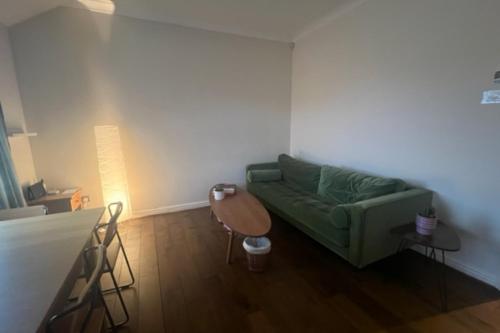 a living room with a green couch and a table at Peaceful 1 Bedroom Flat near Highbury and Islington in London