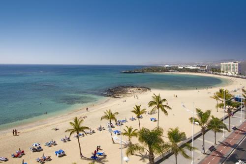 a view of a beach with palm trees and the ocean at Hotel Lancelot in Arrecife